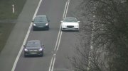 Ujęcie z drona gdzie białe Audi wyprzedza pojazdy w miejscu zabronionym.