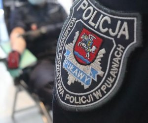 napis komenda powiatowa policji w Puławach na mundurze w tle policjant oddający krew