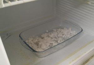 szklane naczynie z białym narkotykiem w lodówce