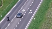 Kard z filmu nagranego przez drona na którym widzimy jak auto osobowe wyprzedza motocykl w miejscu nie dozwolonym.