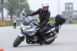 policjant na placu jeździ motocyklem