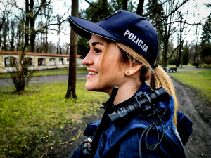 Uśmiechnięta policjantka w trakcie patrolu w parku.