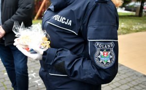 policjantka trzyma zapakowane ciasteczka.