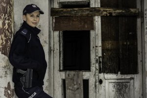 Policjantka przy starym budynku.