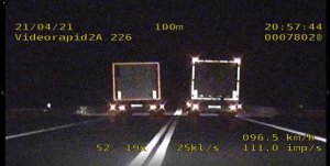 Pojazd ciężarowy w porze nocnej wyprzedza inny pojazd ciężarowy. Na zdjęciu widać dane z videorejestratora między innymi datę, godzinę i prędkość .