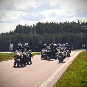 Grupa policyjnych motocyklistów na drodze.