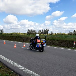 Motocyklista w kamizelce z napisem ratownik medyczny jedzie między przeszkodami.