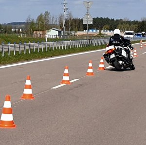 Policyjny motocyklista jedzie po torze przeszkód.