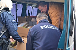 Policjanci pakują paczki z produktami.