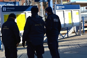 policjant z funkcjonariuszami SOK na dworcu