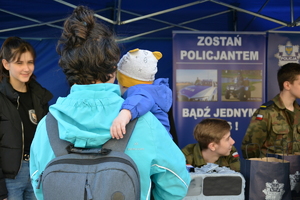 kobieta z dzieckiem przy stoisku policyjnym