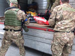 policjanci z Ukrainy ładują karmę na przyczepę
