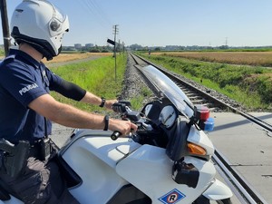 policjant na motocyklu spogląda na tory