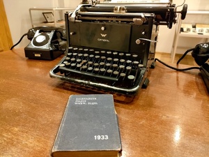 biurko na nim maszyna do pisania telefon i kalendarzyk