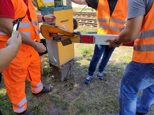 pracownicy kolei naprawiają szlaban