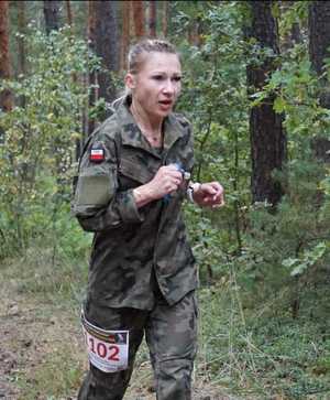 Zdjęcie przedstawia opolską policjantkę biegnącą w konkursie 27. Biegu o Nóż Komandosa w Lublińcu.