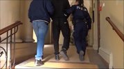 policjant i policjantka prowadzą zatrzymanego