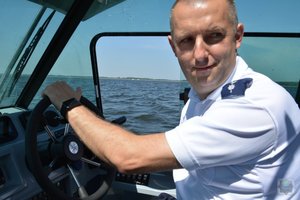 policjant za sterami łodzi motorowej