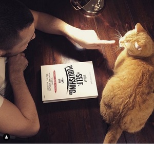 Aleksander Sowa wraz ze swoim kotem i książką