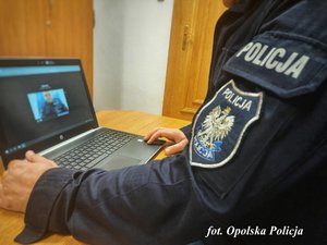 policjant siedzi przed komputerem